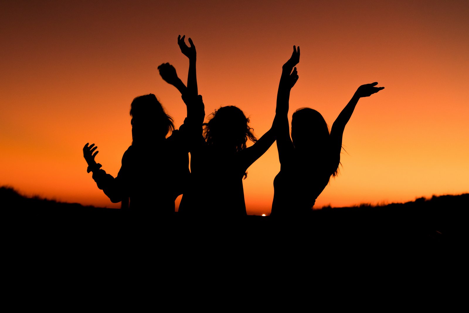 Morocco bachelorette trip — two women celebrating at Sahara desert sunset, Merzouga